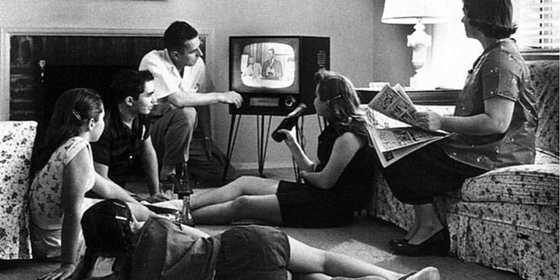 Människor runt en TV på femtiotalet